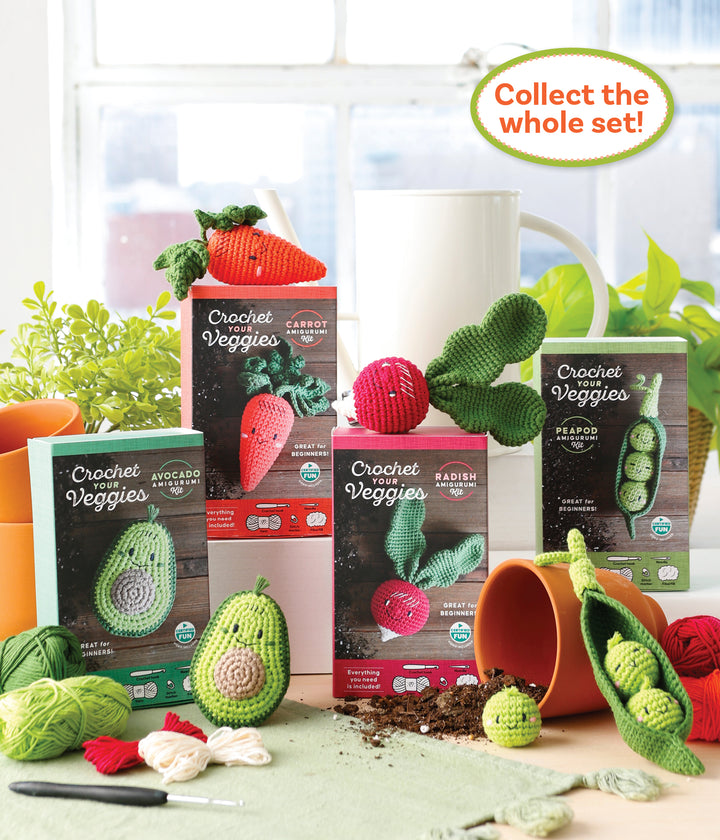 The Crochet Your Veggies Amigurumi Kit Avocado by Schiffer Publishing, Ltd. is shown with finished avocado and veggie crochets, yarn, hooks, a small carrot, spilled soil, an overturned pot, and the text “Collect the whole set!”.