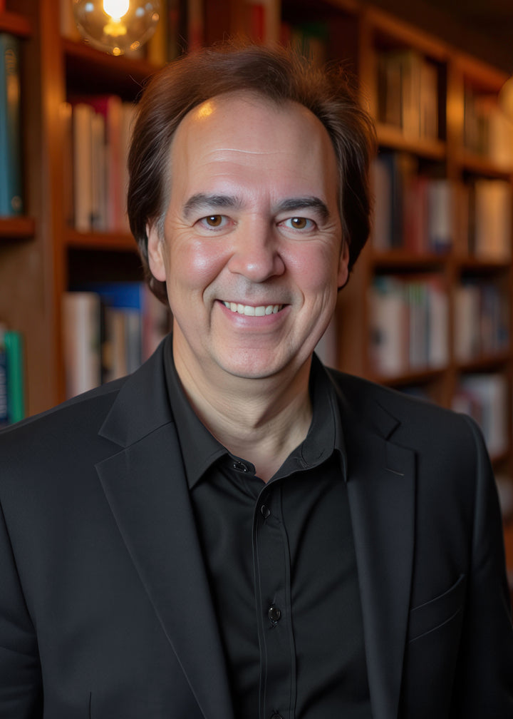 A man with medium-length brown hair and a playful Milk Mustache smiles at the camera in a warmly lit library, wearing a black suit—reminiscent of classic ads. Product: Milk Mustache by Schiffer Publishing, Ltd.