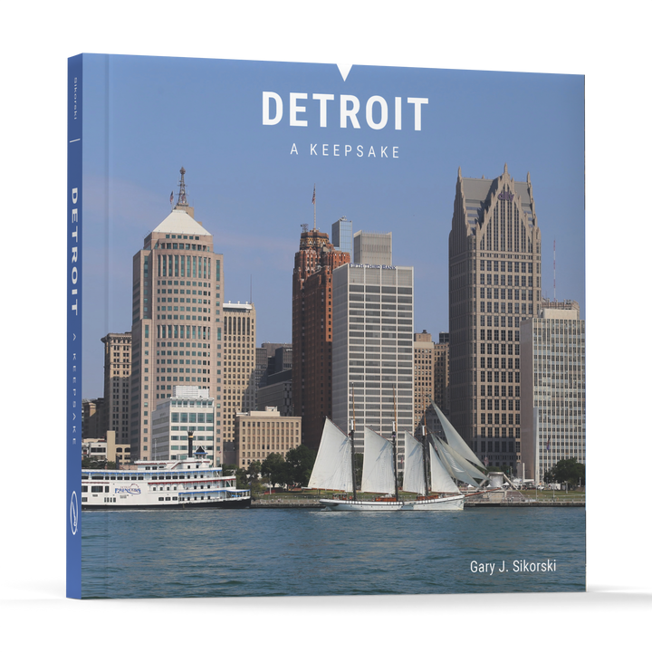 Detroit by Schiffer Publishing, Ltd. is a Detroit photo book featuring downtown skyscrapers and two boats on the river—a perfect Motor City souvenir.