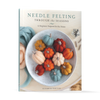 Needle Felting Through the Seasons by Schiffer Publishing, Ltd. features a cover with a white bowl of colorful felted pumpkins, wool fibers, and felting needles—ideal inspiration for your next needle felting project.