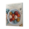The cover of Needle Felting Through the Seasons by Schiffer Publishing, Ltd. shows a bowl of colorful felted pumpkins and acorns with wool roving and the subtitle: 12 Beginner Needle Felting Projects with Step-by-Step Instructions for the Home.