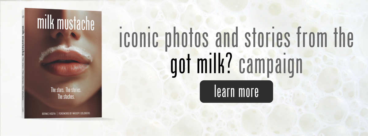 Book cover titled Milk Mustache featuring a mouth with a milk mustache, next to text reading iconic photos and stories from the got milk? campaign and a learn more button.