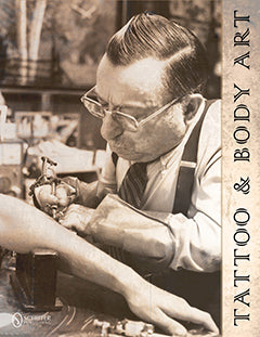 A vintage photo of a man in glasses and suspenders tattooing someones forearm. The image has a sepia tone and TATTOO & BODY ART is written along the right edge.