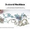 Hands arrange blue and metallic beads on a white surface, ready to craft a 3-strand necklace using techniques from Beads & Wires Jewelry by Schiffer Publishing, Ltd. The text "3-strand Necklace" appears above.
