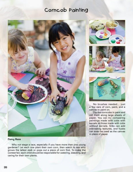 Two children sit outside, grinning as they paint corn cobs at a table filled with art supplies, inspired by activities from "Kinder Gardens" by Schiffer Publishing, Ltd. Painted corn and leaves complete this fun gardening scene.