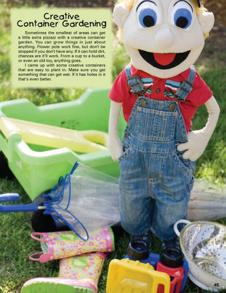 A smiling puppet in overalls and a red shirt stands with gardening tools, boots, and a container—Kinder Gardens by Schiffer Publishing, Ltd. inspires kids' gardening and outdoor play in a sunny garden.