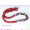 Making Simple Felted Jewelry by Schiffer Publishing, Ltd. features fiber art with vibrant bead clusters arranged along a handmade red knitted necklace, beautifully displayed on a white background.